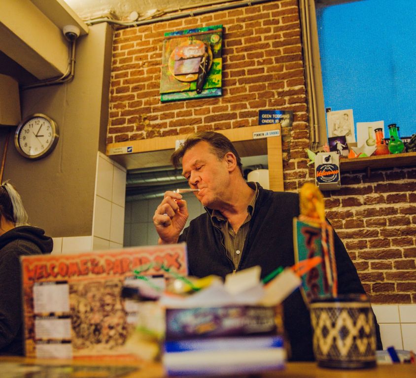 man smoking a joint at an amsterdam coffeeshop paradox