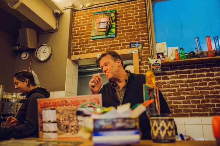 man smoking a joint at an amsterdam coffeeshop paradox