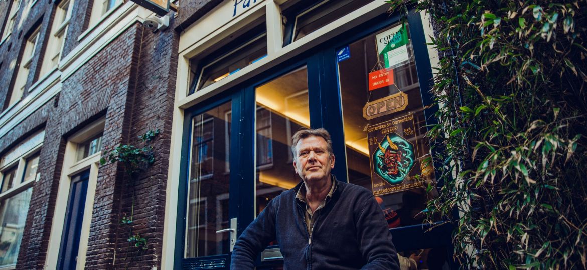 Amsterdam coffeeshop owner sitting in front of Paradox coffeeshop in the Jordaan Amsterdam
