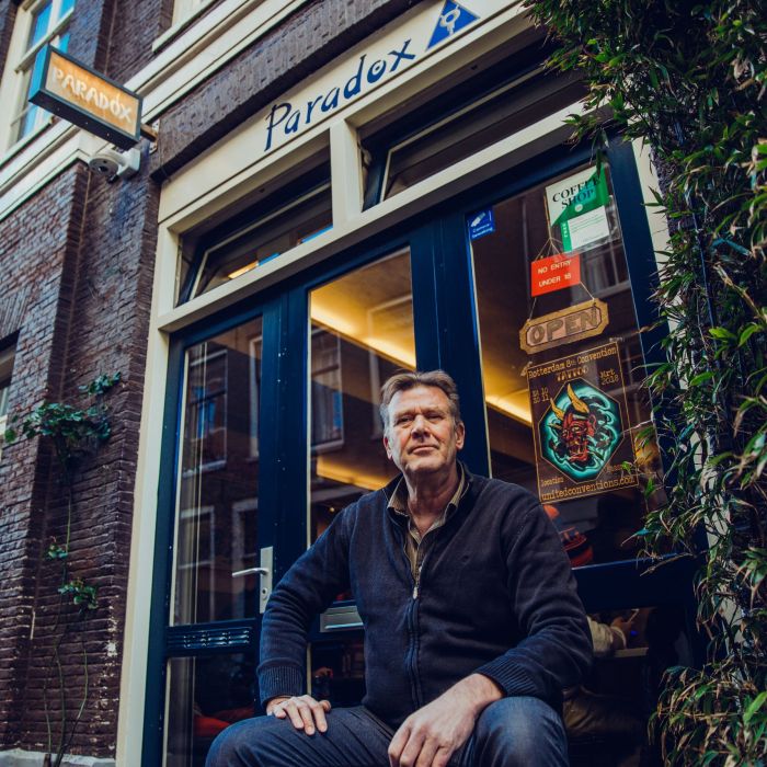 Amsterdam coffeeshop owner sitting in front of Paradox coffeeshop in the Jordaan Amsterdam