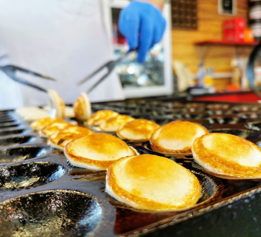 Freshly made Dutch poffertjes cooking in a cast iron