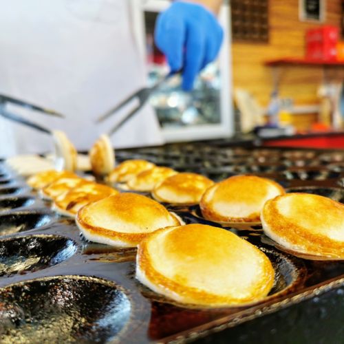 Freshly made Dutch poffertjes cooking in a cast iron