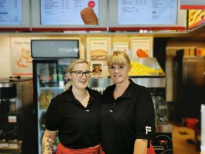 Two FEBO stall vendors standing and smiling in front of their stall
